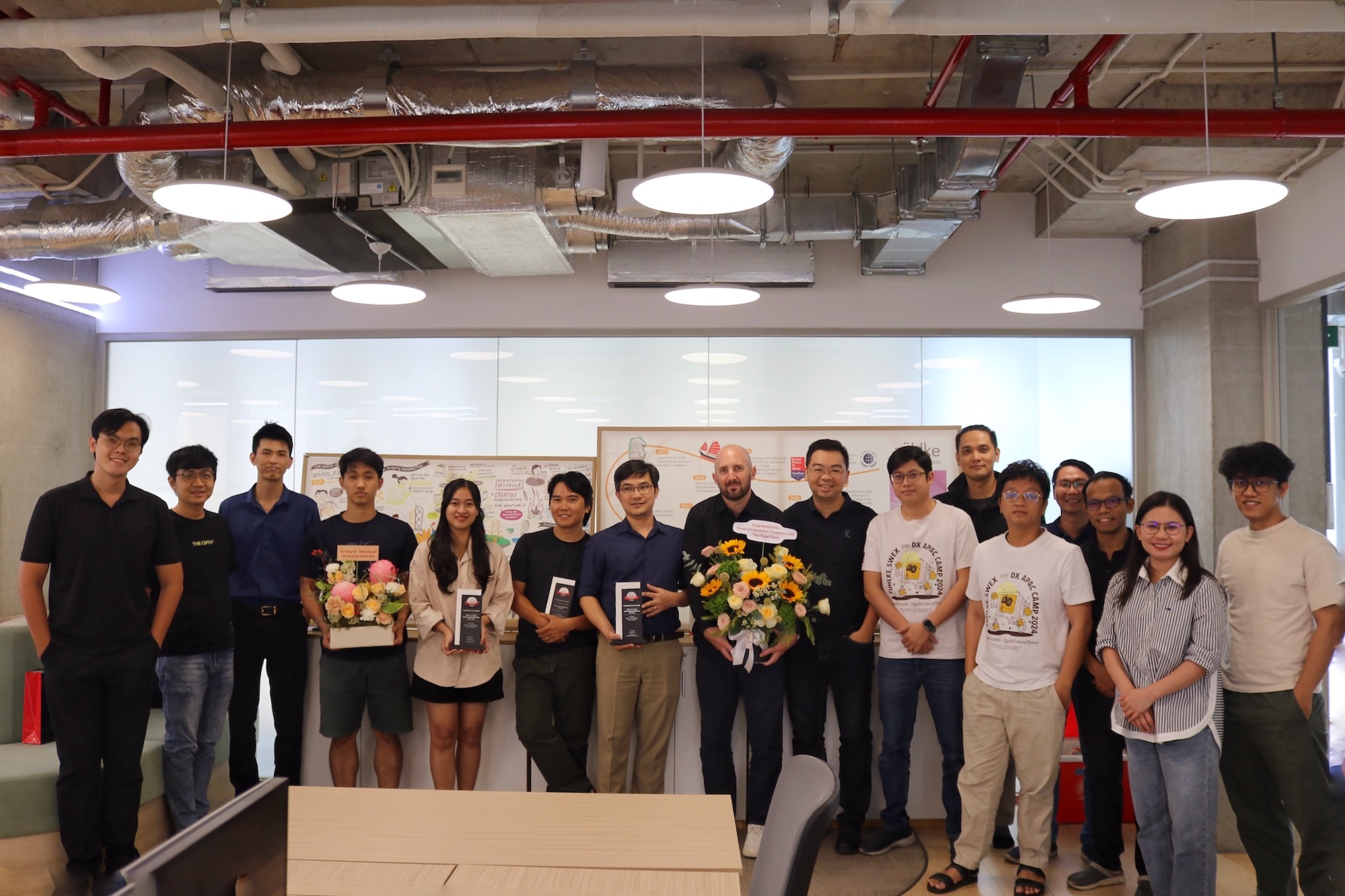 A group of colleagues in the office celebrating the Best IT Companies in Vietnam 2025 award - ITviec
