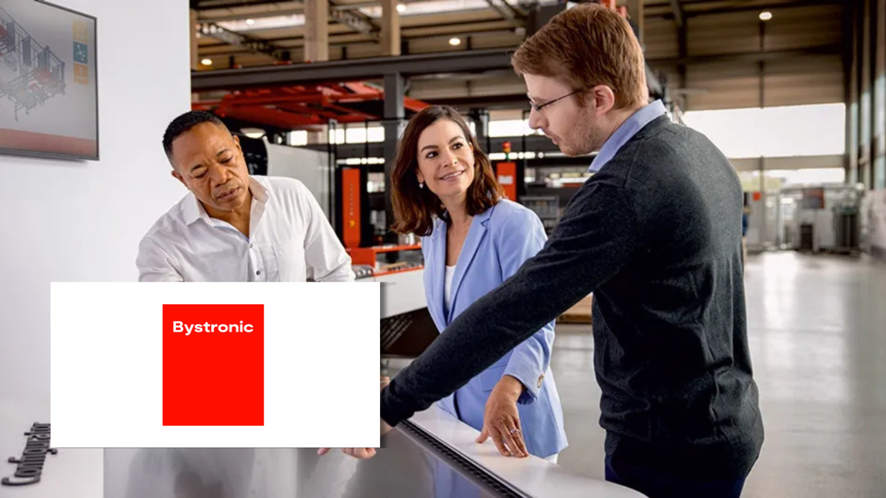 Two colleagues in business attire consulting with a technician in a manufacturing facility, next to the Bystronic logo.