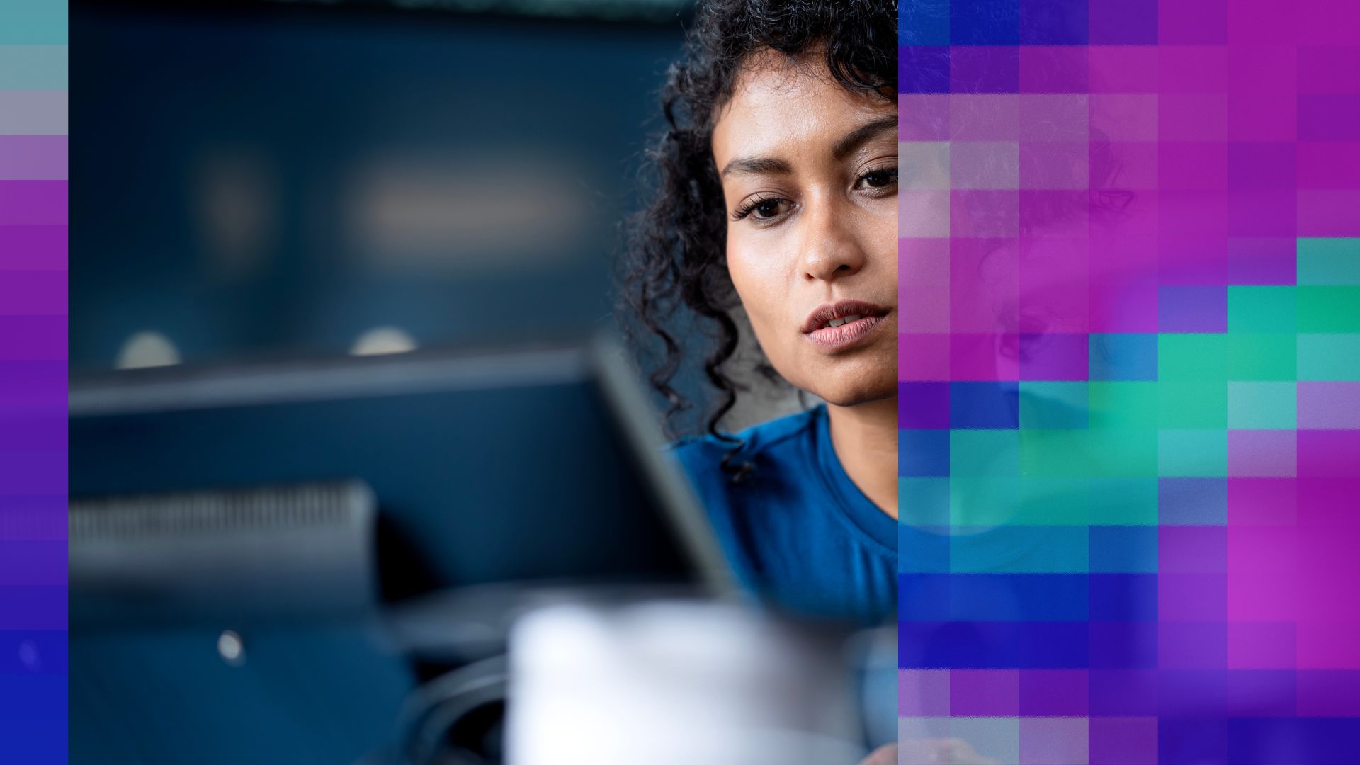 A woman with curly hair focuses intently on a computer screen in a modern workspace. The right side of the image features a colourful digital overlay of blue, purple, and green pixel blocks, creating a futuristic and tech-inspired effect and illustrating the struggle with AI adoption challenges and scaling from AI pilots to AI impact