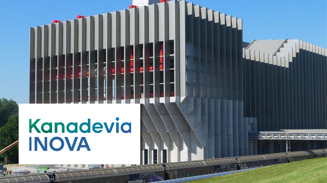 Kanadevia INOVA industrial facility exterior with distinctive vertical cladding, red pipework, and adjacent rail line
