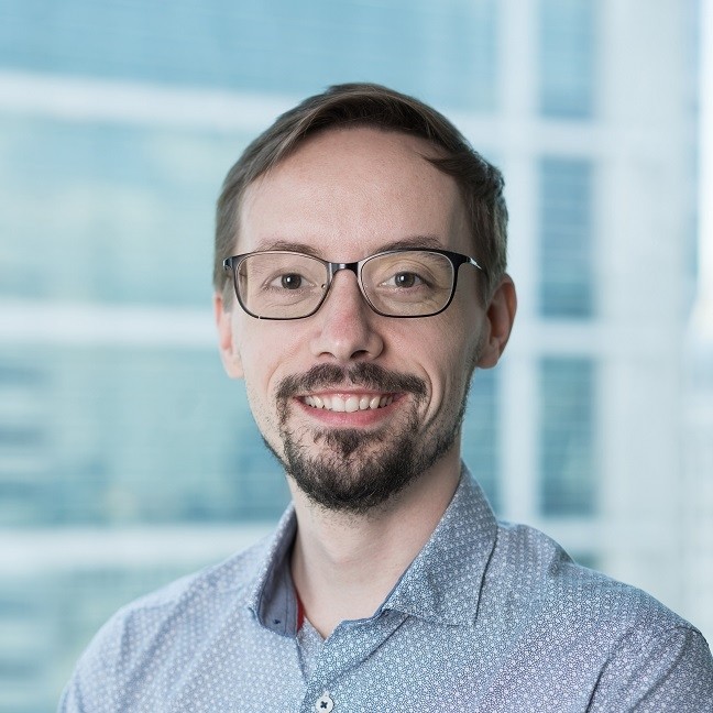 A man with short brown hair and glasses
