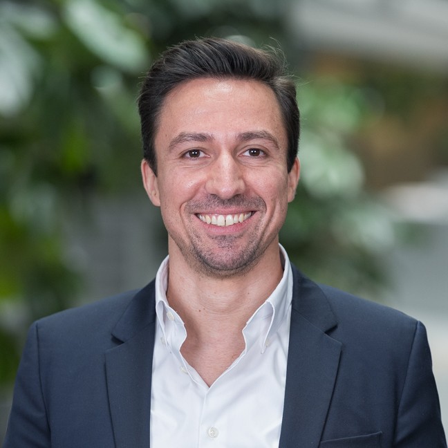 A smiling middle aged man in a business suite portrait in an office setting