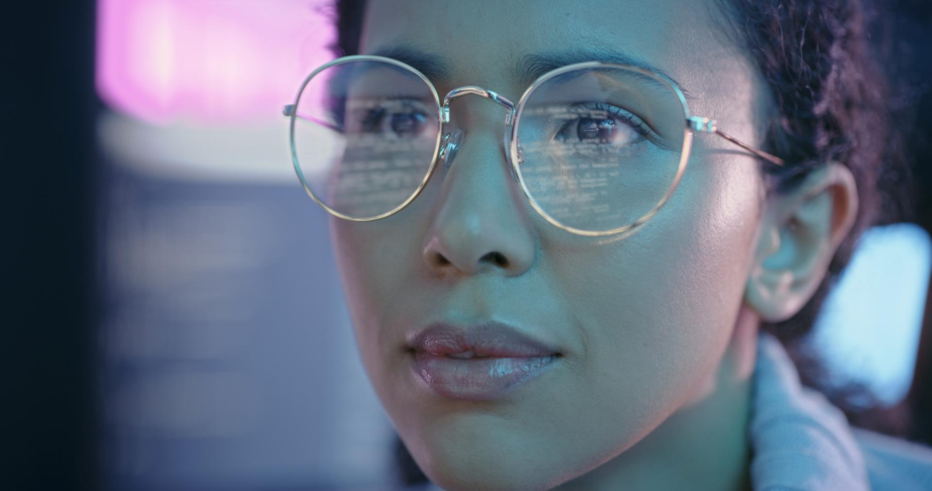 Female programmer working at night on coding and cybersecurity systems, focused on AI and database development in a modern office.