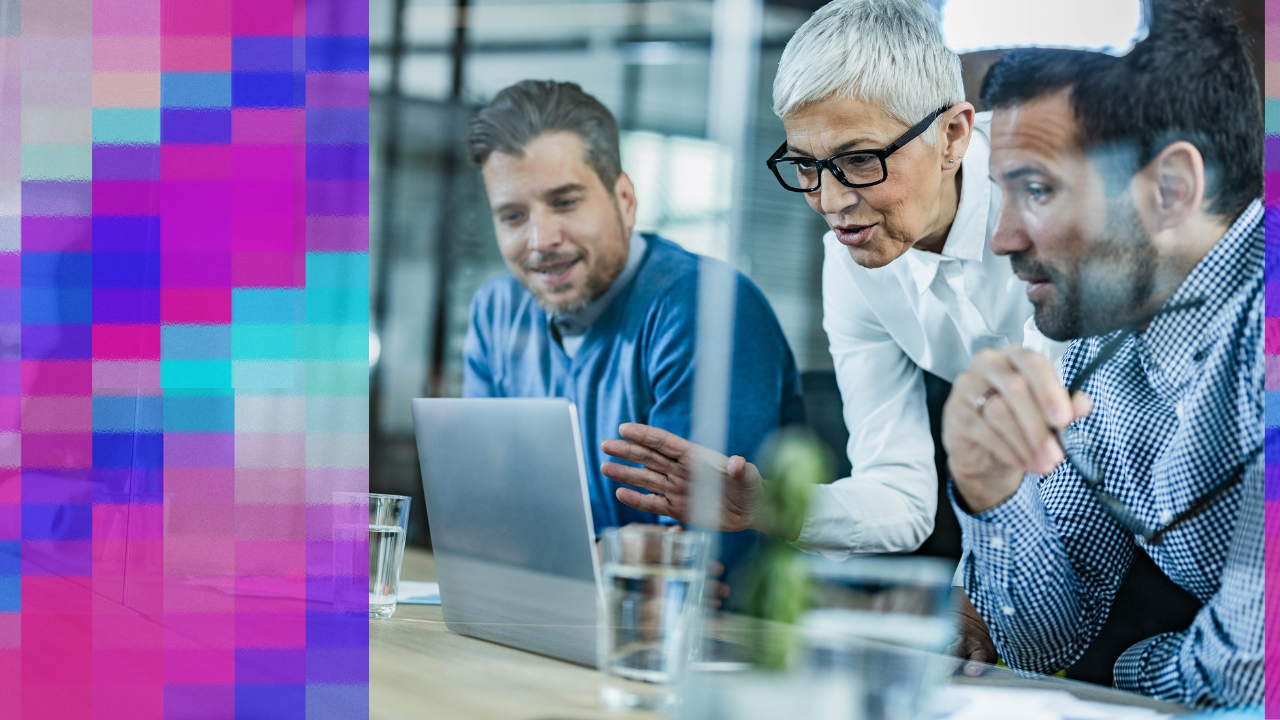 Senior woman guiding two colleagues at a laptop during a focused problem-solving discussion, illustrating collaborative decision-making.
