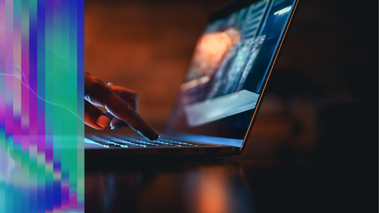 Close-up of a hand typing on a laptop, illuminated by screen light, representing hands-on development work.